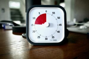 Pomodoro timer clock on a brown desk
